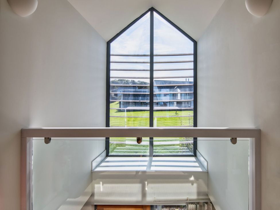 A staircase with a window and handrail at Arundell in Marhamchurch