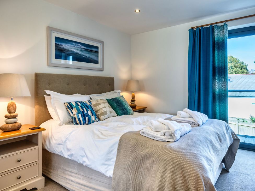 A bedroom with a bed and bedside lamps at Arundell in Marhamchurch