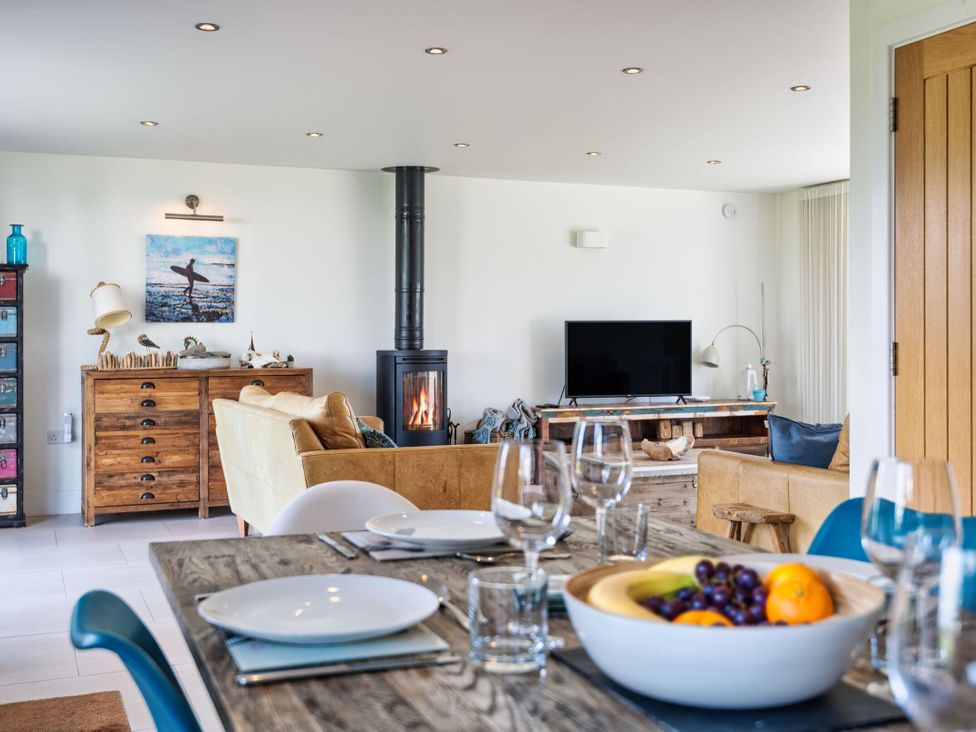 A living room with a fireplace and seating area at Eagle's Nest in Marhamchurch