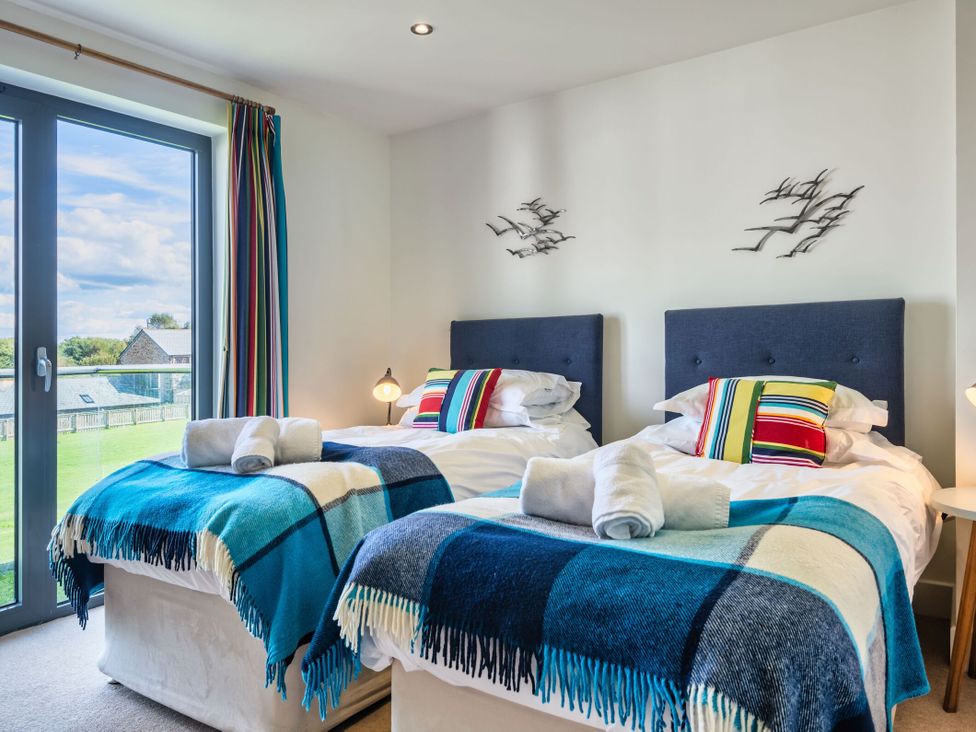 A bedroom with twin beds and a window at Eagle's Nest in Marhamchurch