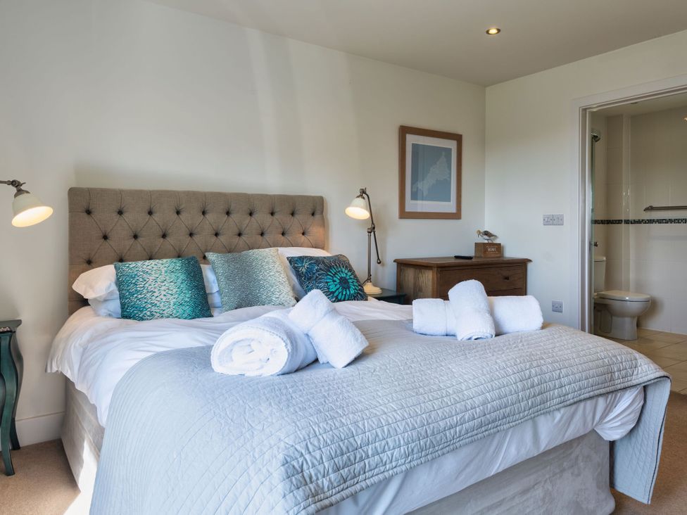 A bedroom with a bed and towels on the bed at Eagle's Nest in Marhamchurch