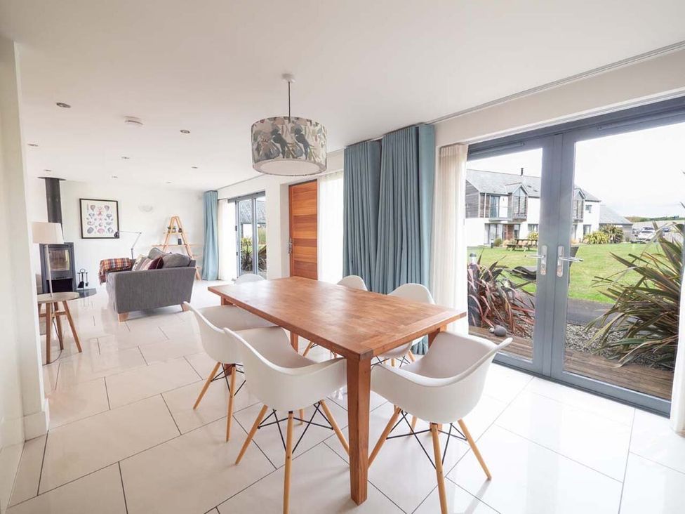 A dining room with a table and chairs at Medlands in Marhamchurch