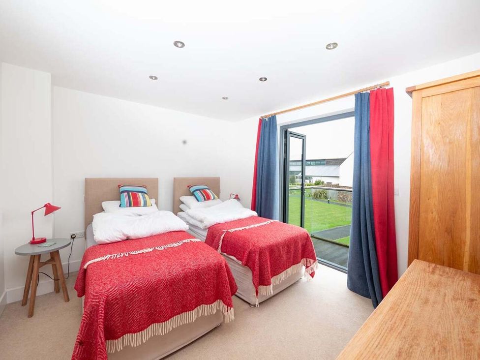 A bedroom with twin beds and a view of the garden at Medlands in Marhamchurch