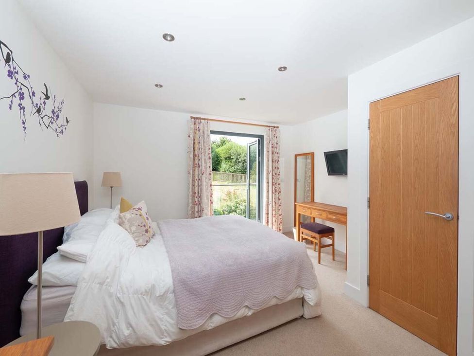 A bedroom with a bed and dressing table at Medlands in Marhamchurch