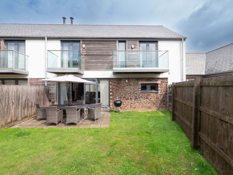 A garden area with seating and grill at Medlands in Marhamchurch