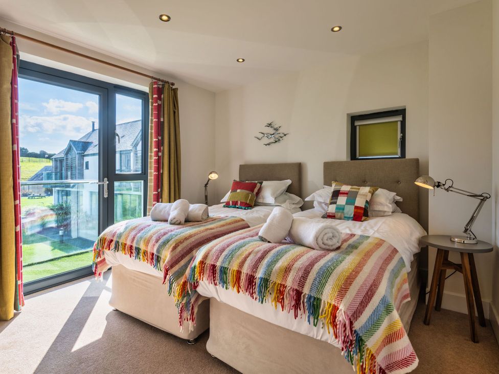A bedroom with two beds and a view of the outdoors at Moleyns in Marhamchurch