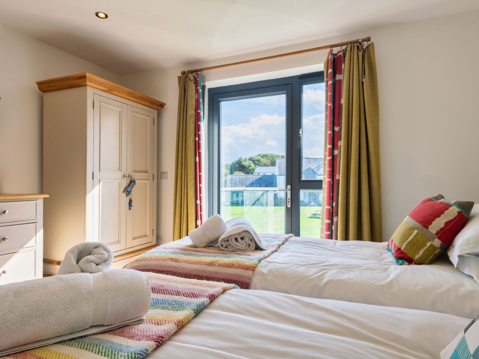 A bedroom with two single beds and a wardrobe at Moleyns in Marhamchurch