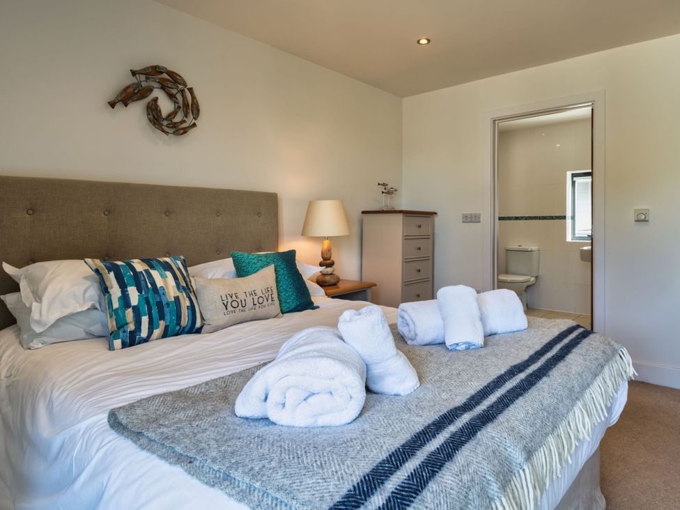 A bedroom with a bed and pillows at Moleyns in Marhamchurch