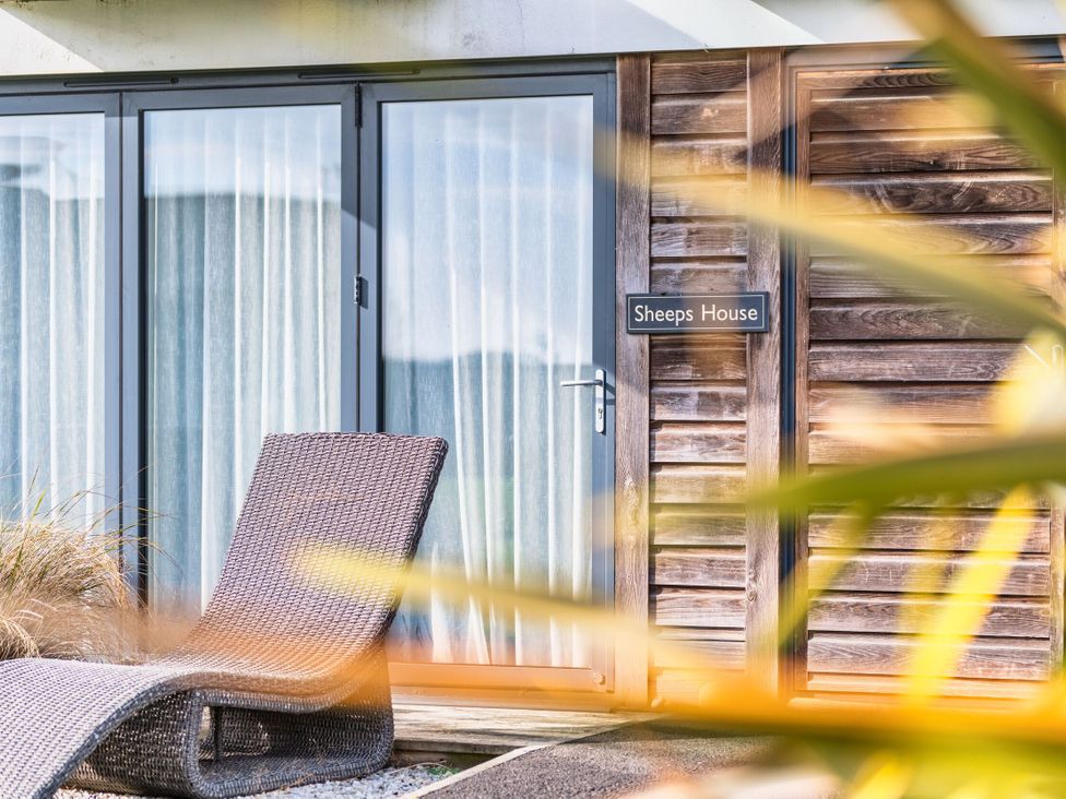 An entrance with a chair and nameplate at Sheep's House in Marhamchurch