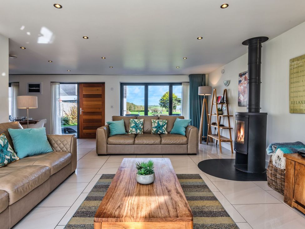 A living room with a fireplace and sofas at Sheep's House in Marhamchurch