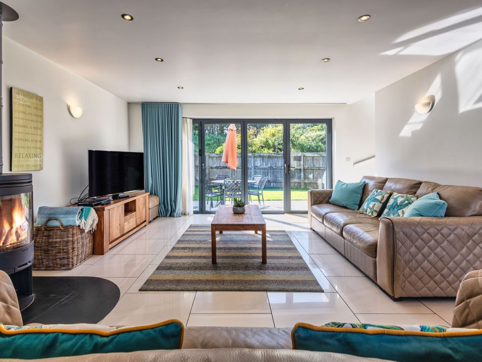 A living room with a sofa, coffee table and television at Sheep's House in Marhamchurch