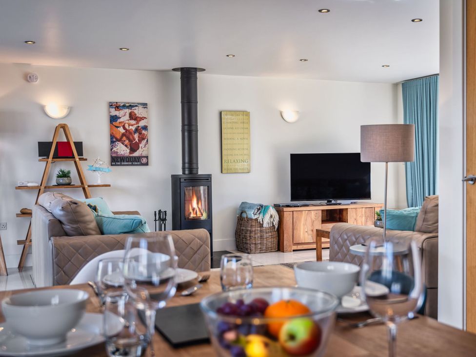 A living room with a sofa, TV, and fireplace at Sheep's House in Marhamchurch