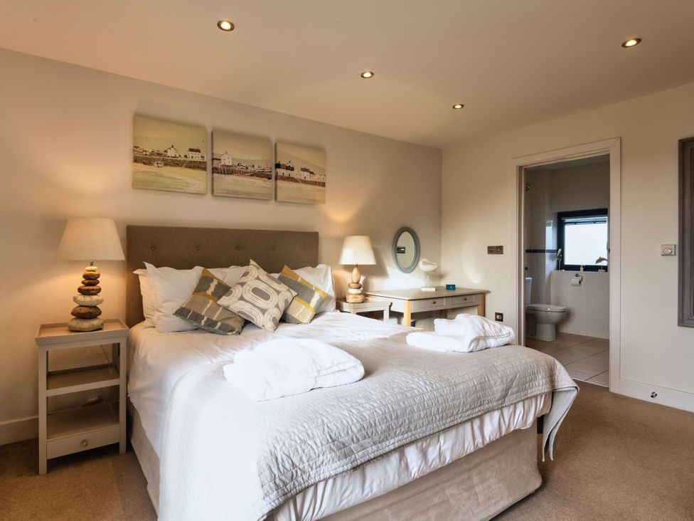 A bedroom with a bed and bedside tables at Trevelyan in Marhamchurch