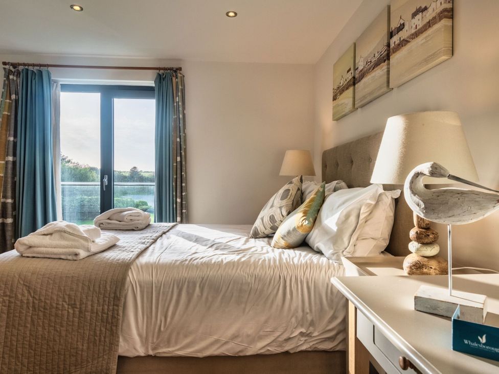 A bedroom with a bed and a window at Trevelyan in Marhamchurch