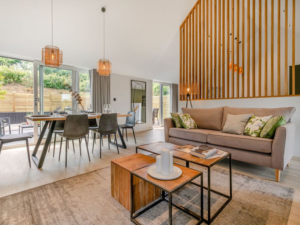 A living room with a sofa and dining table at Gwari Spa Barn 3.0 in Marhamchurch