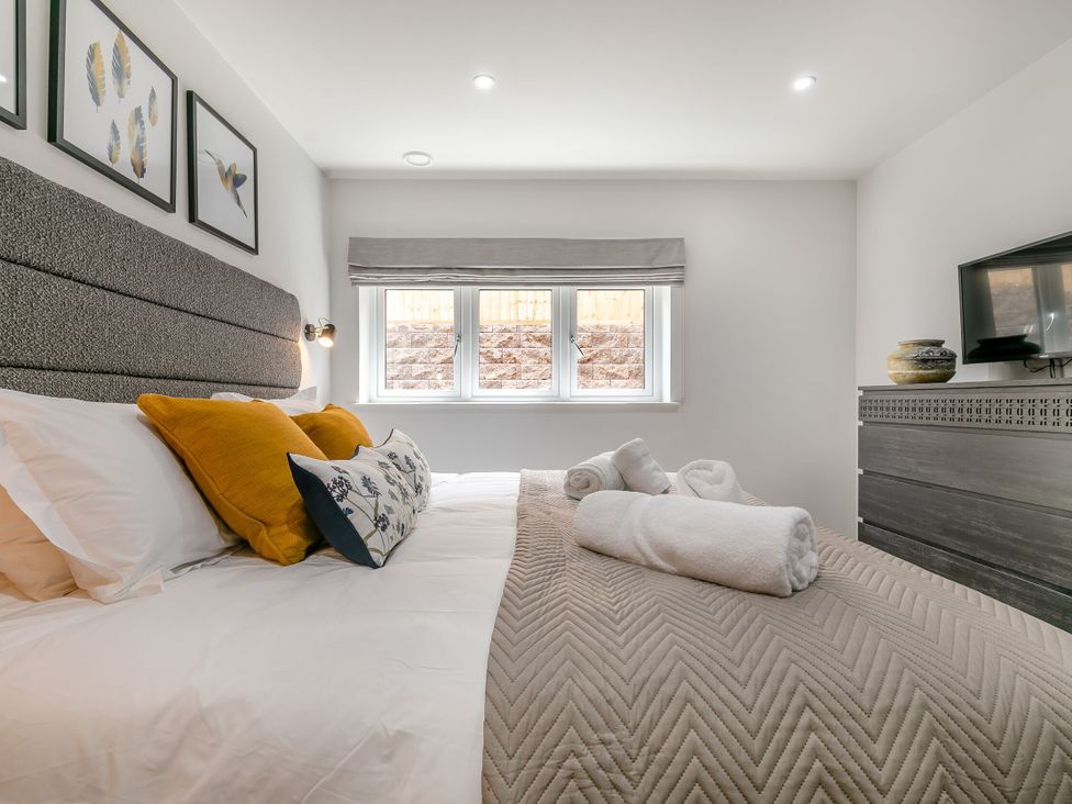 A bedroom with a bed and nightstand at Gwari Spa Barn 3.0 Marhamchurch