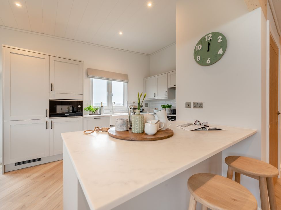 A kitchen with a countertop and stools at Trelowen 3.0 Spa in Marhamchurch