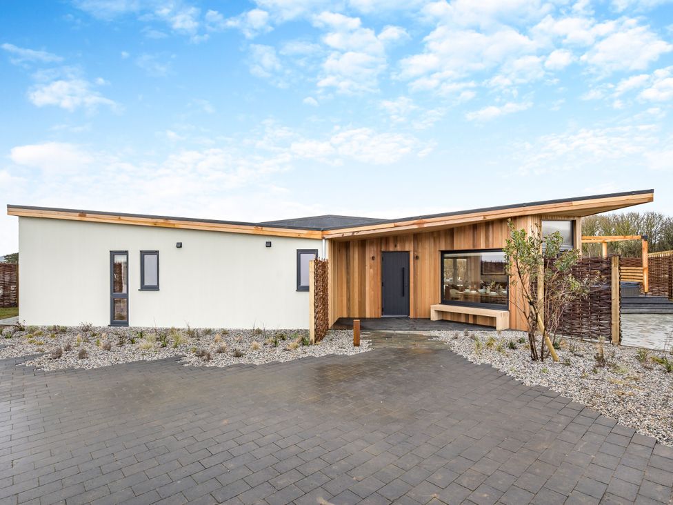 An exterior view of a modern house with pathway and landscaping at Trelowen 3.0 Spa in Marhamchurch
