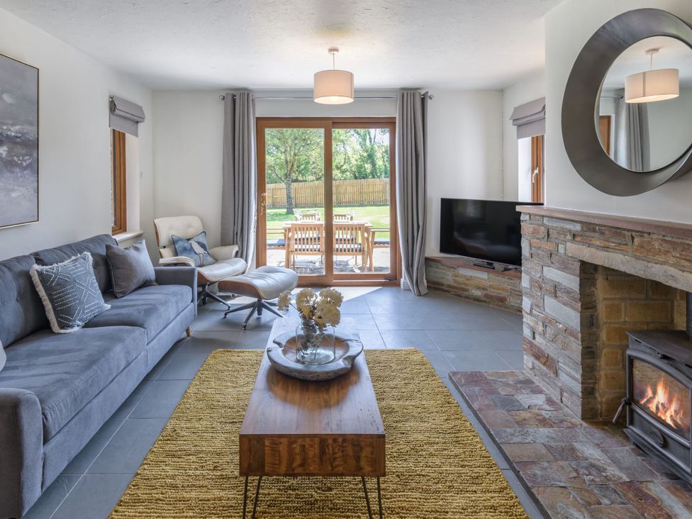 A living room with a sofa and coffee table at Windy Hills Spa in Marhamchurch