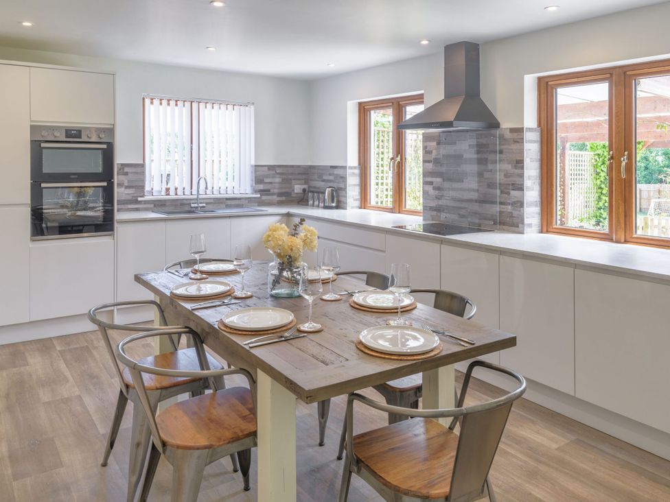 A kitchen with a dining table and chairs at Windy Hills Spa in Marhamchurch