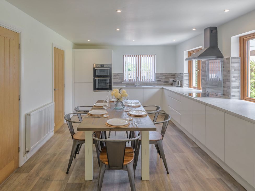 A kitchen with dining table and chairs at Windy Hills Spa in Marhamchurch