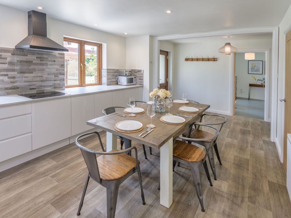 A dining room with a wooden table and chairs at Windy Hills Spa Marhamchurch