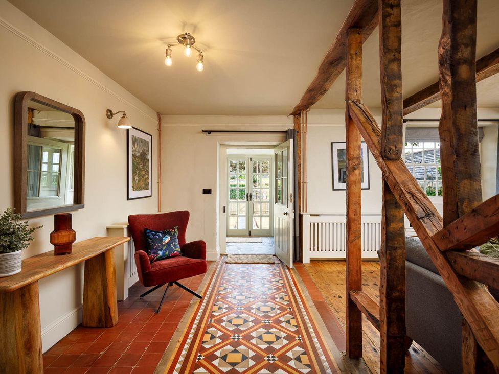 An entryway with a chair and table at Whalesborough Farmhouse Spa in Marhamchurch