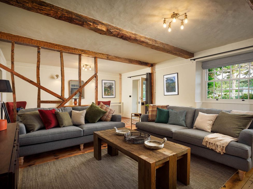 A living room with sofas and a coffee table at Whalesborough Farmhouse Spa Marhamchurch