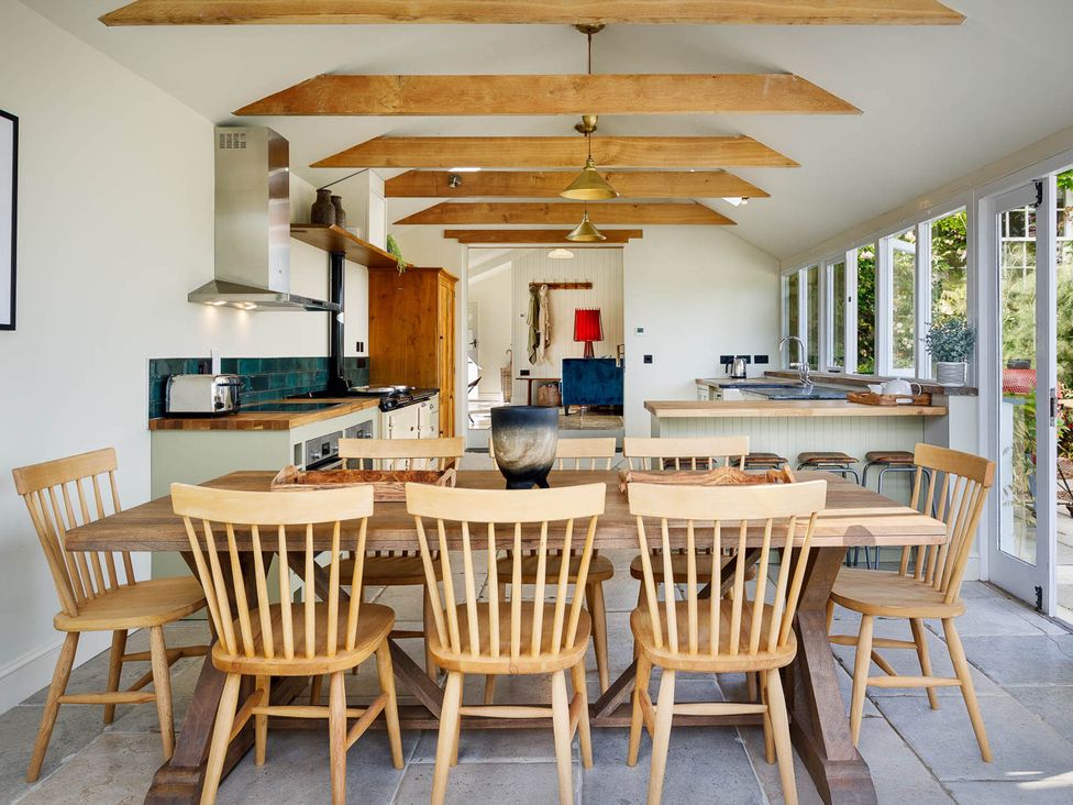 A kitchen with wooden table and chairs at Whalesborough Farmhouse Spa Marhamchurch