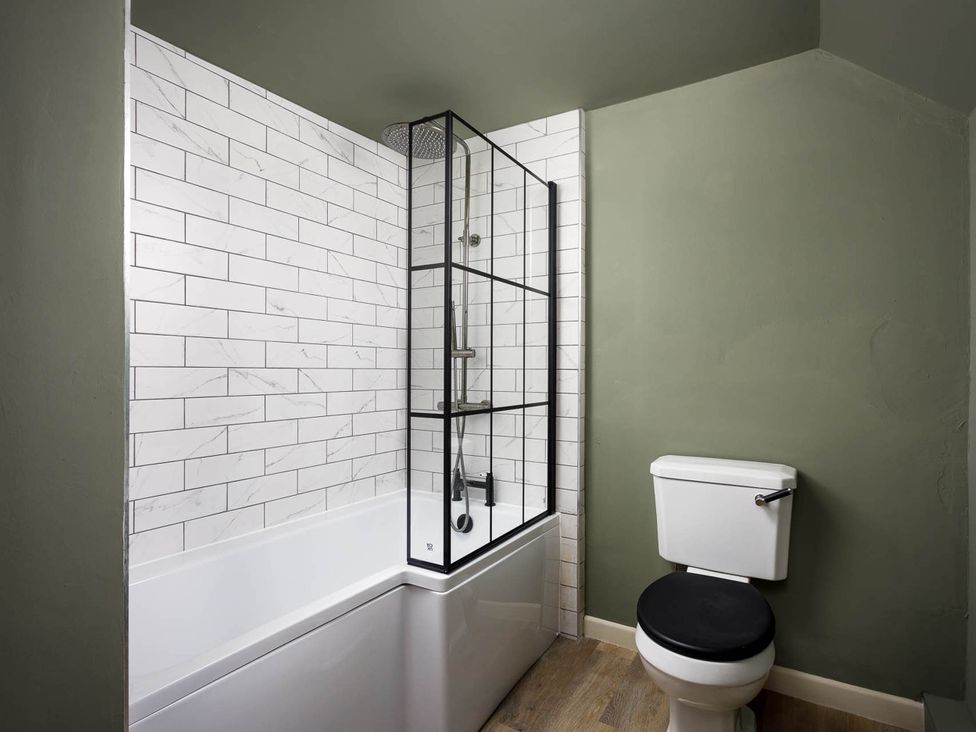 A bathroom with a bathtub and shower at Whalesborough Farmhouse Spa in Marhamchurch