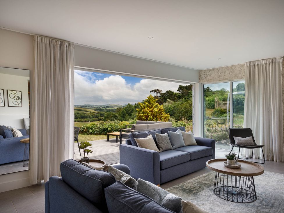 A living room with a sofa and coffee table at Whalesborough Cottage Spa, Marhamchurch