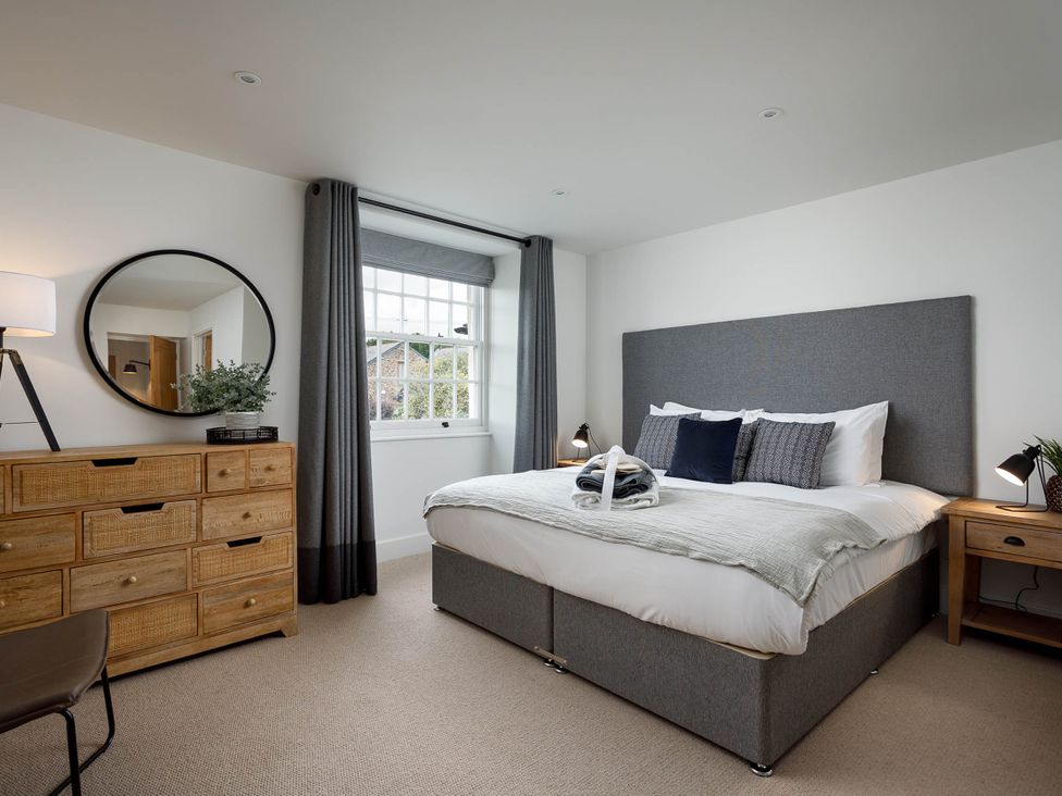 A bedroom with bed and dresser at Whalesborough Cottage Spa in Marhamchurch