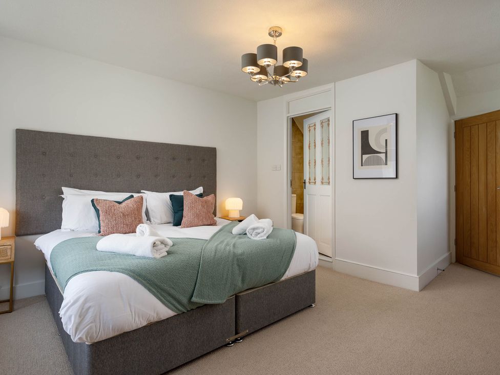 A bedroom with a bed and lamp at Whalesborough Cottage Spa in Marhamchurch