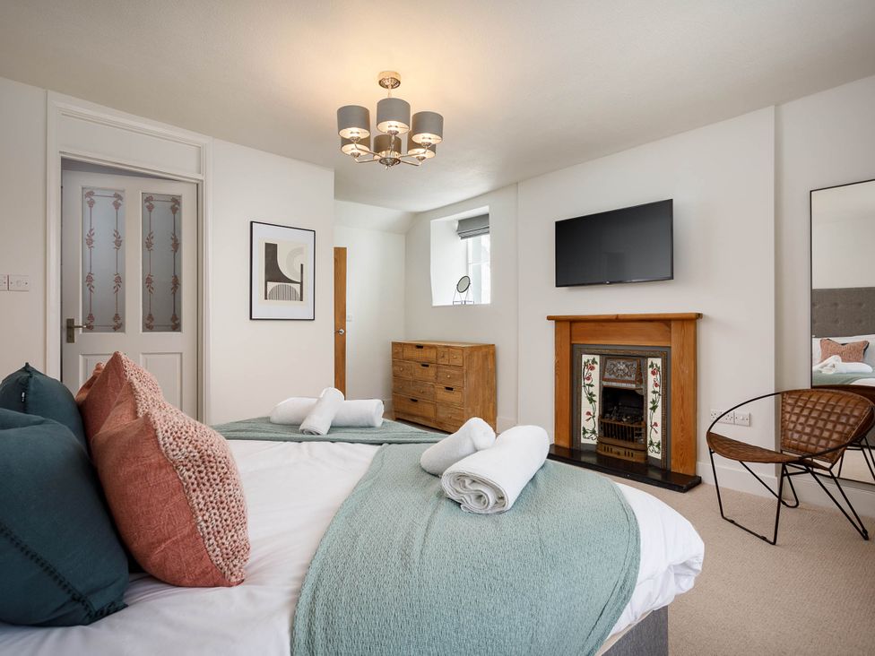 A bedroom with a bed and tv at Whalesborough Cottage Spa in Marhamchurch