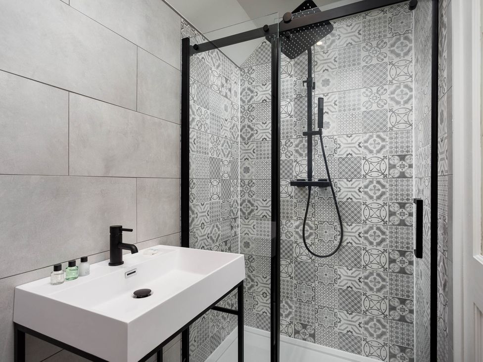 A bathroom with shower and sink at Whalesborough Cottage Spa in Marhamchurch