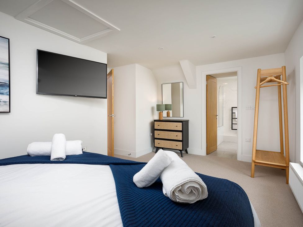 A bedroom with towels on a bed at Whalesborough Cottage Spa Marhamchurch
