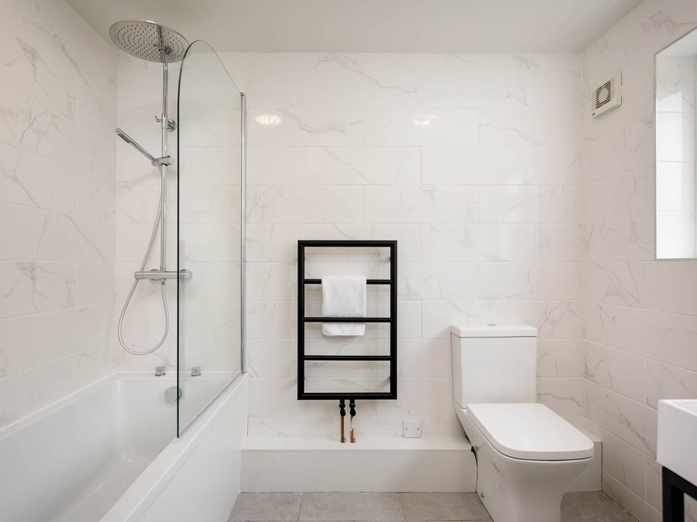 A bathroom with a shower and bathtub at Whalesborough Cottage Spa in Marhamchurch