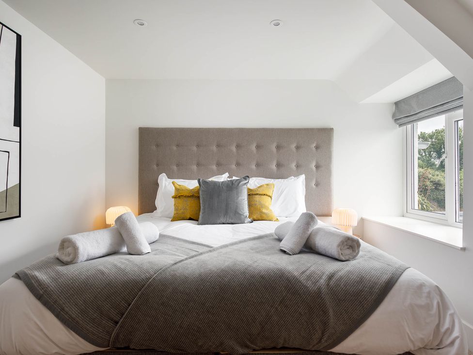 A bedroom with a bed and pillows at Whalesborough Cottage Spa Marhamchurch