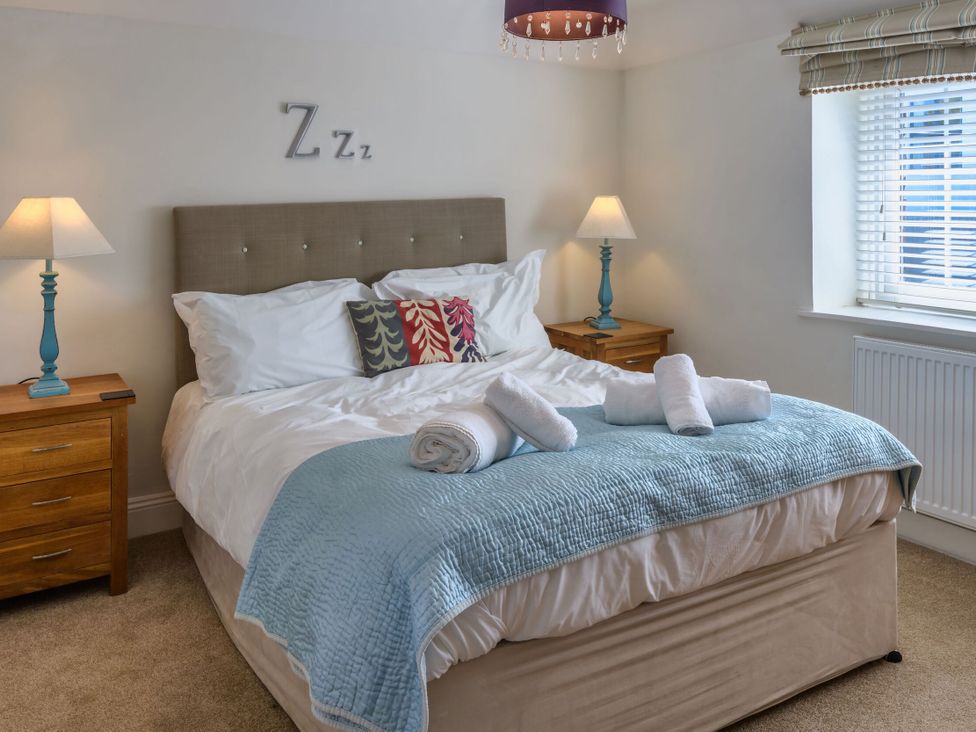 A bedroom with a bed and nightstands at Calf House Spa Marhamchurch