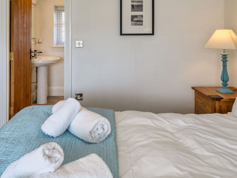 A bedroom with a bed and towels arranged at Calf House Spa in Marhamchurch