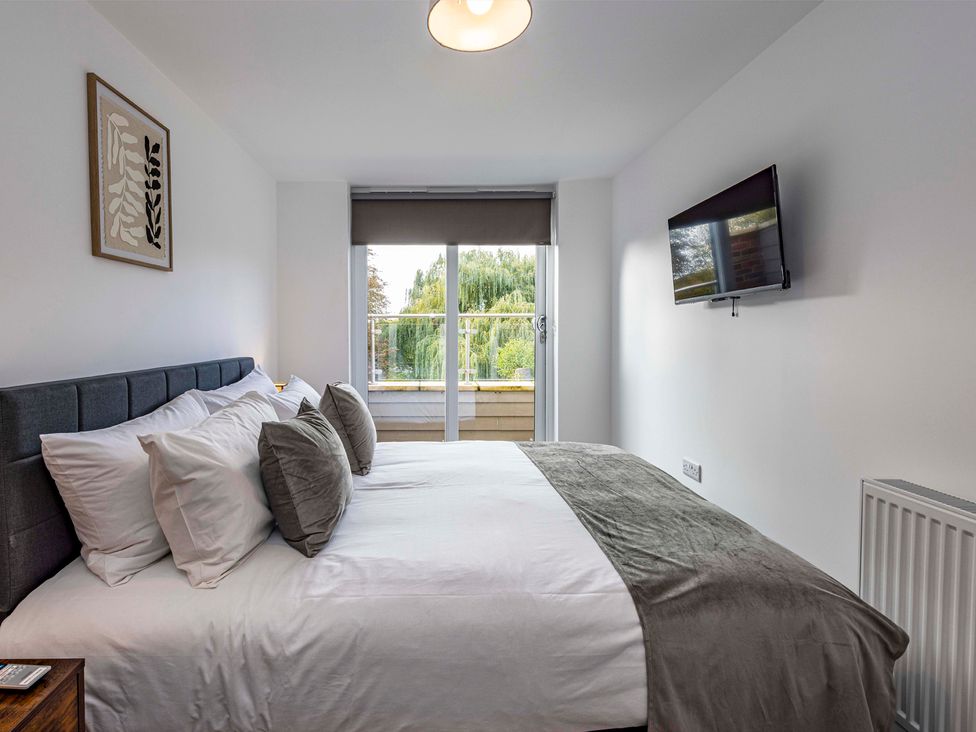 A bedroom with a double bed and a television at 7 Riverside Mews in Derby