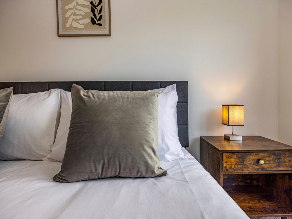 A bedroom with a bed and nightstand at 7 Riverside Mews in Derby