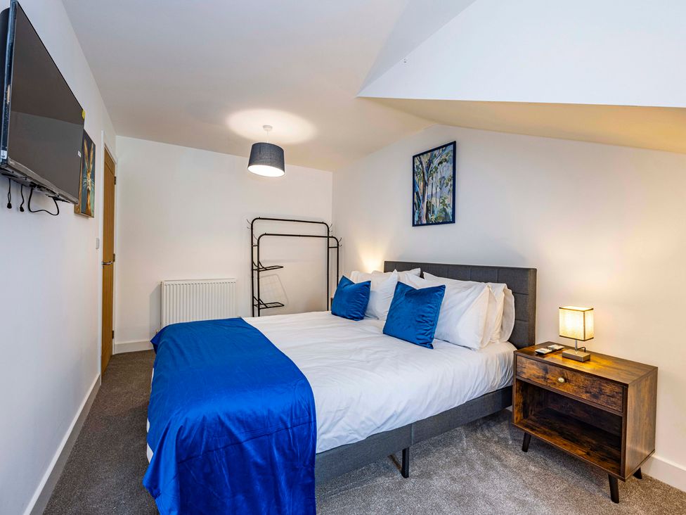 A bedroom with a bed and television at 7 Riverside Mews in Derby