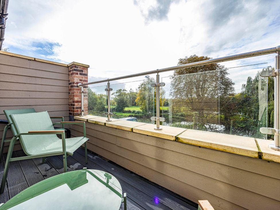 A balcony with chairs and a table at 7 Riverside Mews in Derby