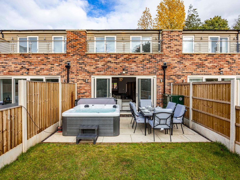 A garden with a hot tub and dining table at 7 Riverside Mews in Derby