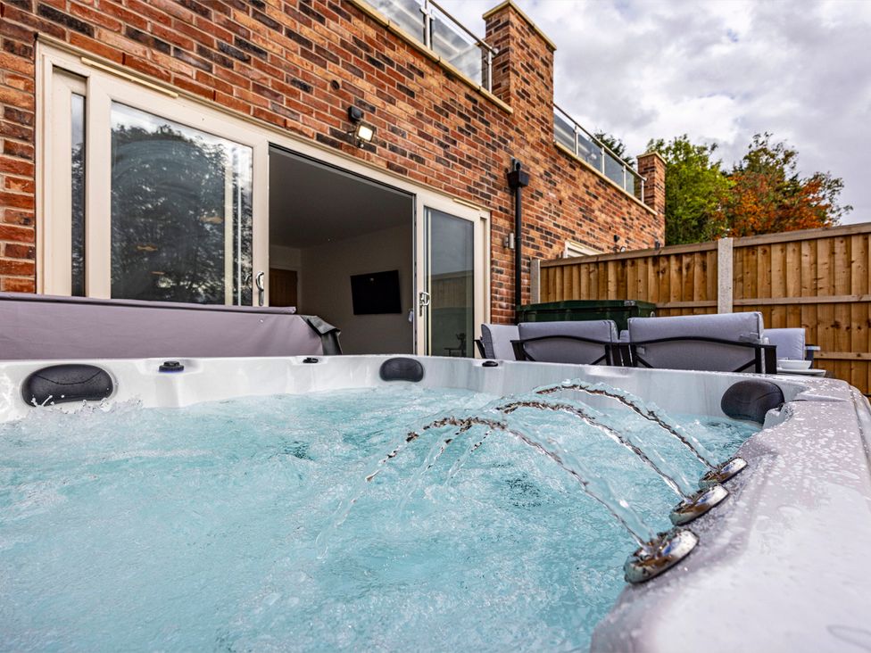 A hot tub with water jets in an outdoor area at 7 Riverside Mews in Derby