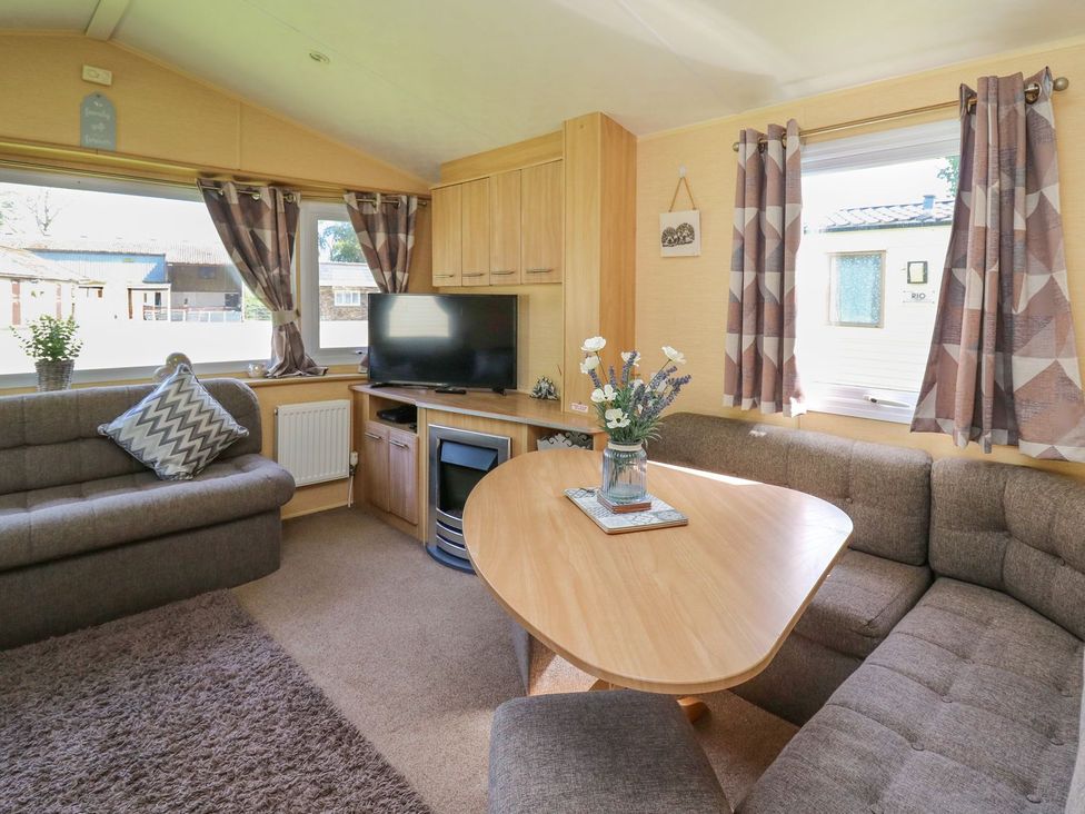 A living room with a TV and a coffee table at Caravan 2 at Blackmoor Farm near tenby
