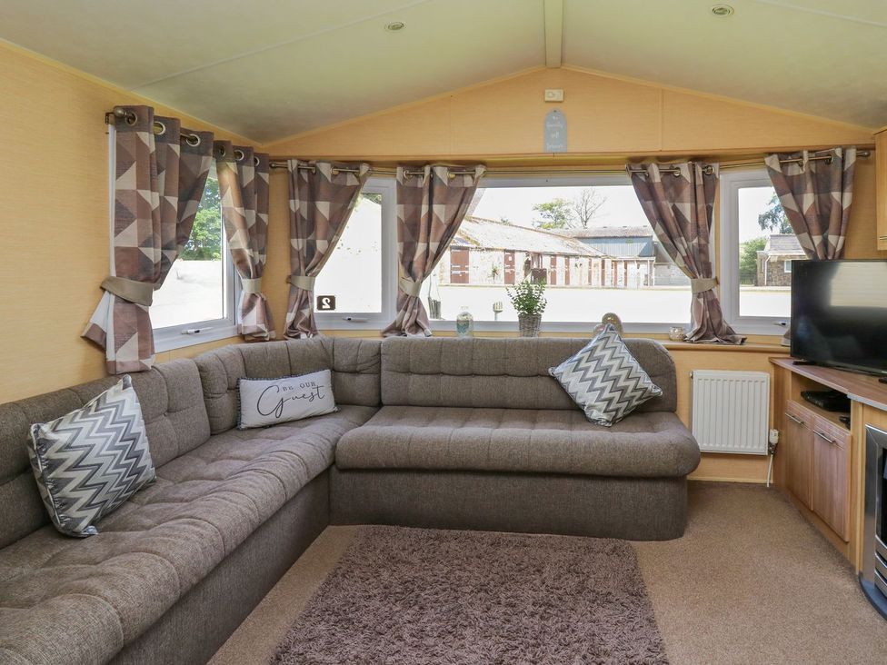 A living room with a sofa and television at Caravan 2 at Blackmoor Farm near tenby