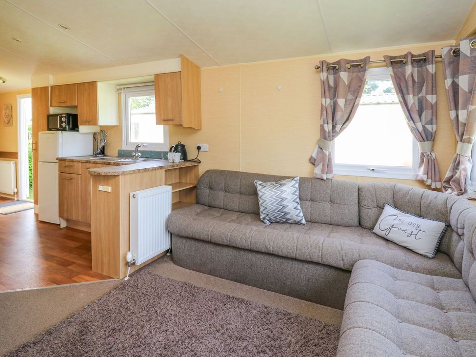 A living room with a sofa and kitchen area at Caravan 2 at Blackmoor Farm near tenby