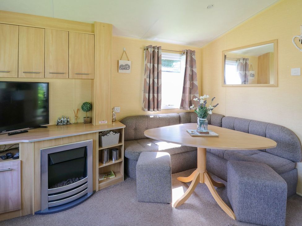 A living room with a sofa and table at Caravan 2 at Blackmoor Farm near tenby